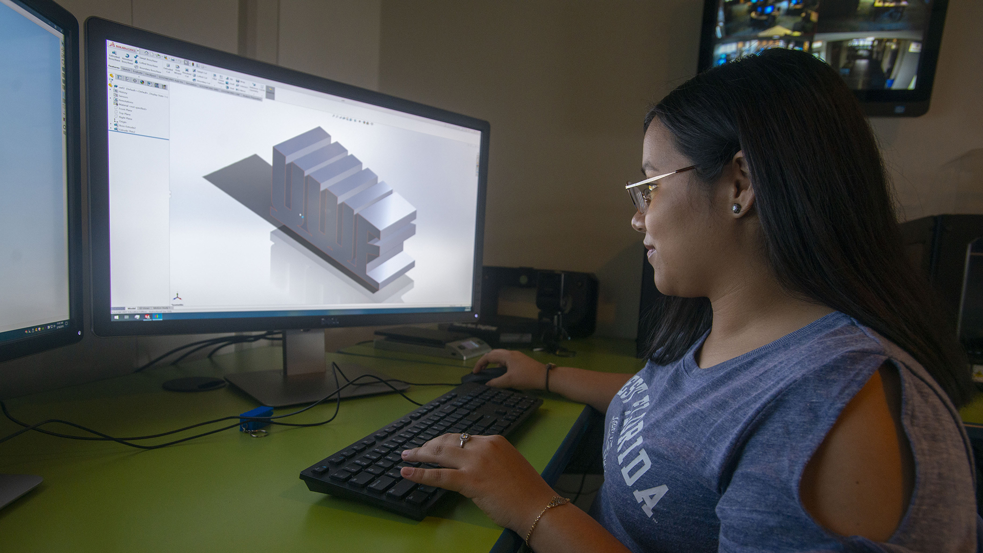 Student using a library computer to design a 3D object.