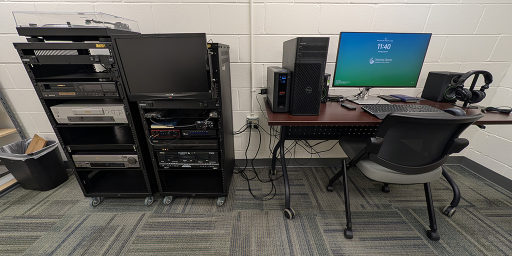 Image of racked digitization equipment and a computer workstation on a desk.