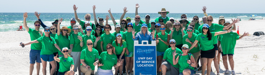 A group of Argos wearing matching t-shirts pose on the beach prior to the Day of Service beach cleanup.