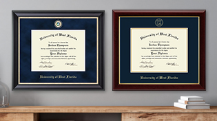 Two diplomas are nicely framed and hung on a wall