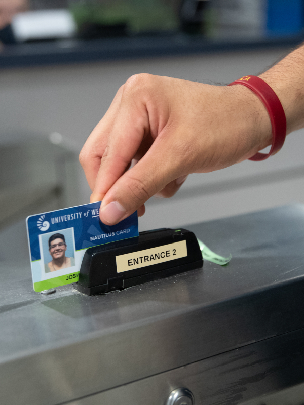 A student swipes his Nautilus Card at the gym facility.
