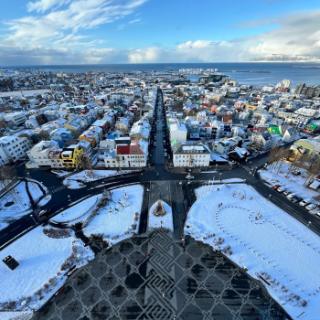A photo from the top of a building looking down over a major street and city buildings.