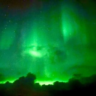 Green northern lights pictured in the sky overhead