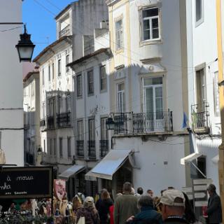 A bustling city street with white buildings and shops