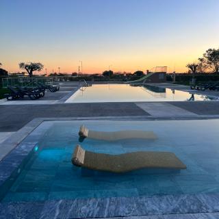 A serene pool with two lounge chairs.