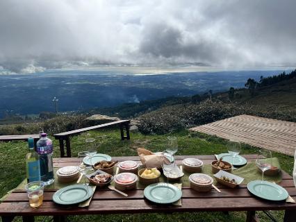 A tablescape is set for a picturesque lunch in the clouds overlooking a valley.