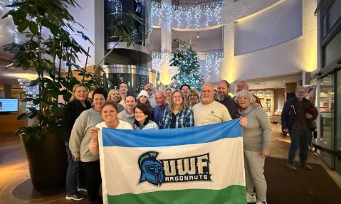 The Argo travelers group poses with the UWF flag in Germany