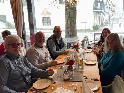Five Argo travelers sit together getting ready to enjoy lunch in Germany