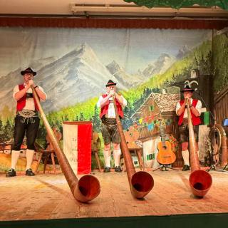 Three performers in traditional German costumes play instruments in a Traditional Tyrolean Dinner and Show