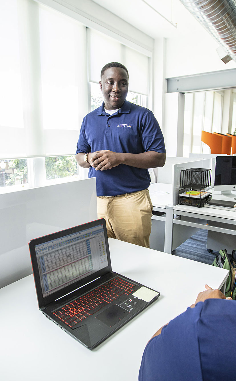 Basil Kuloba talks to several people in a bright modern office