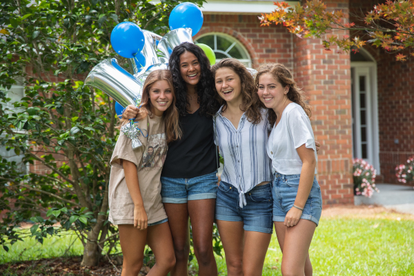 four female incoming freshman pose in front of balloons