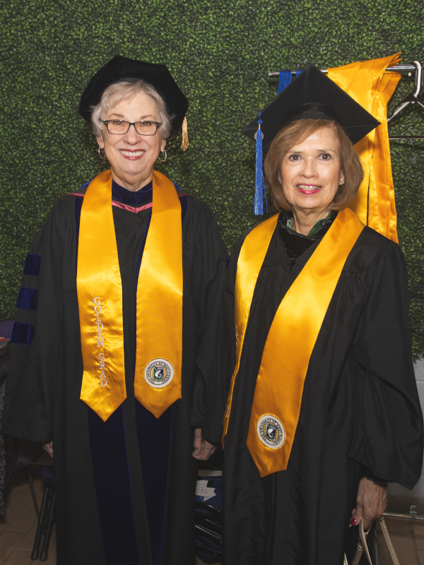 Two classmates from the class of 1974 reunite backstage during the 2024 Golden Graduates celebration.