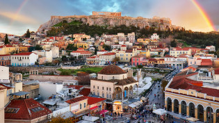 A view of Athens with ruins and a rainbow