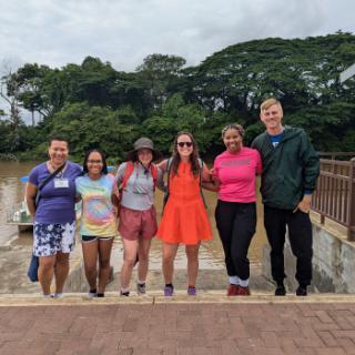 A group of alumni travelers pose on the steps of a plaza in Costa Rica.