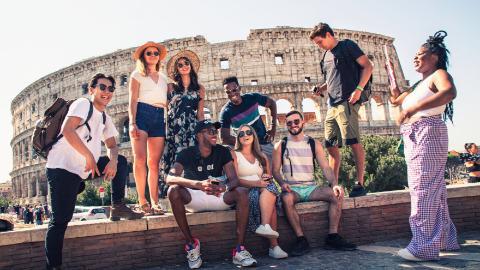 A group of young travelers take in the sights at the Coliseum in Rome.
