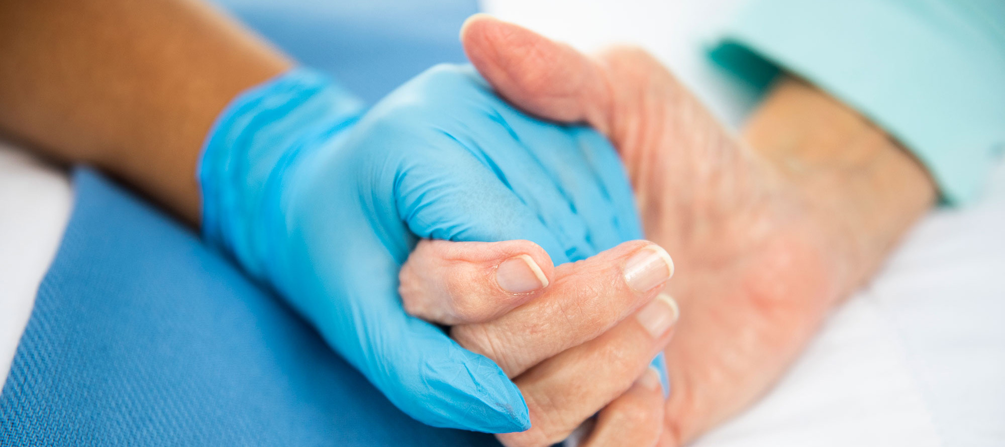 Praise Pettus holding patient's hand