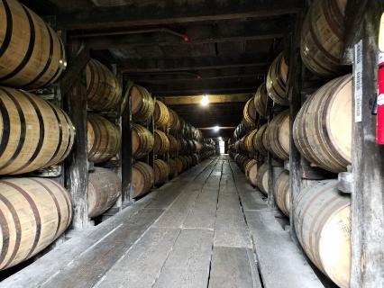 Rows of bourbon barrels aging in racks