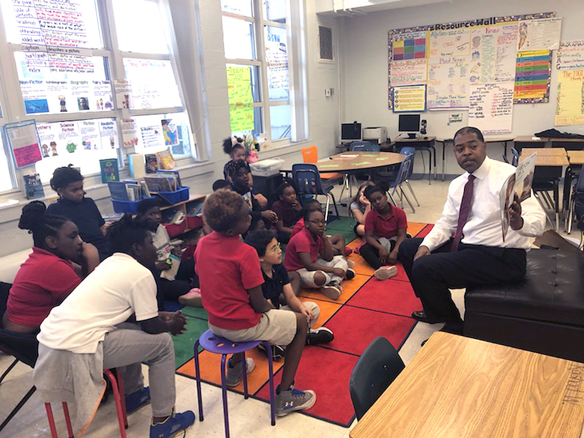 Harrison Peters reading a book to a classroom of children