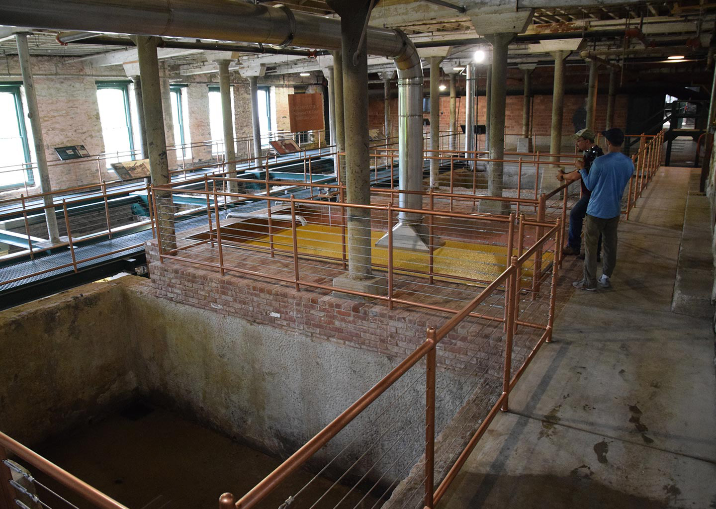 People overlooking historical vats at the Buffalo Trace distillery