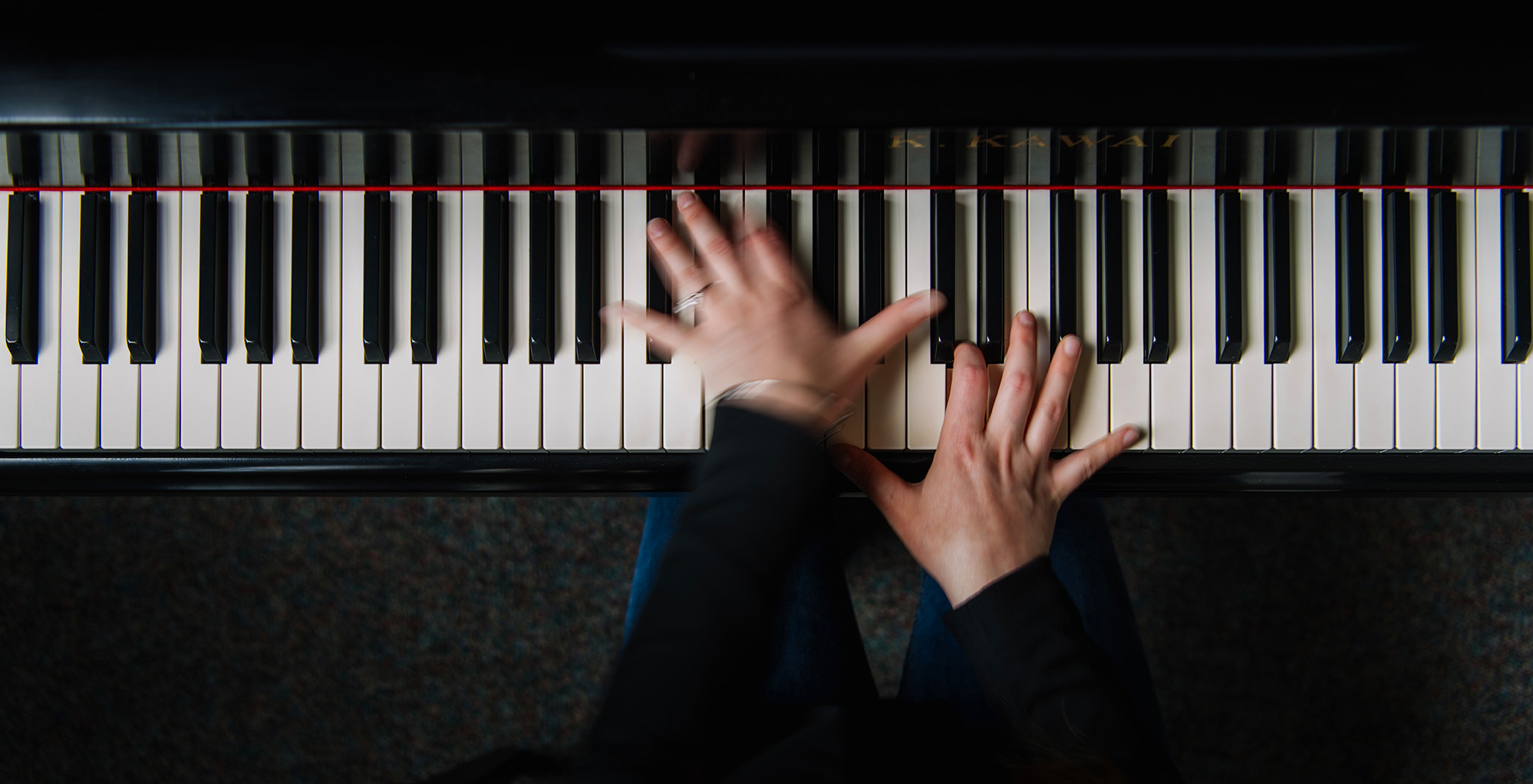 Overhead closeup of blurred hands playing piano