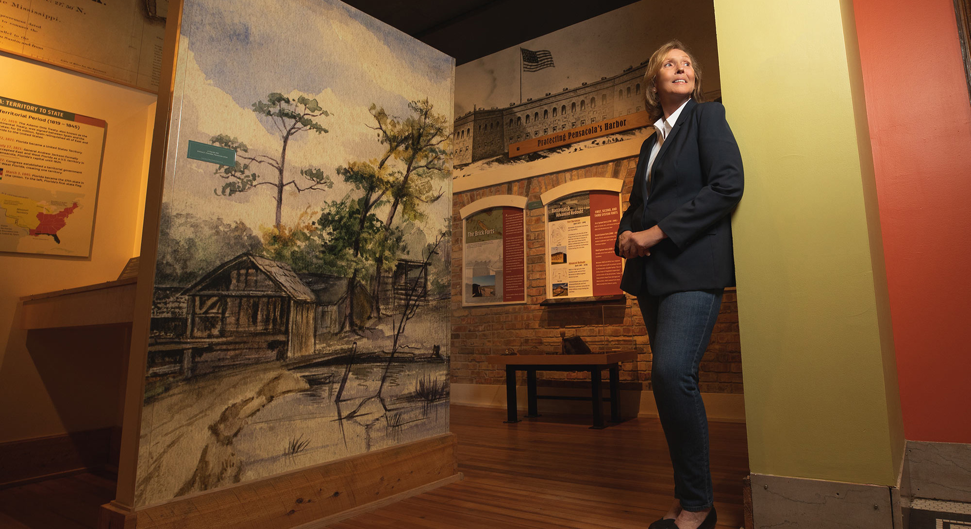 Suzanne Lewis standing in an exhibit at the Pensacola Museum of History