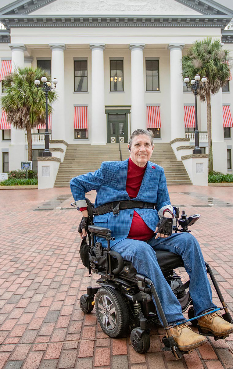 Dr. JR Harding in a wheelchair in front of the Florida state capitol