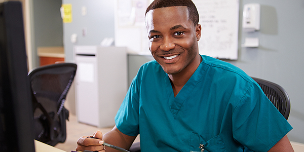 Medical Assistant at office desk in scrubs