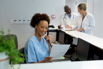 A person working as a medical administrative assistant, managing paperwork, scheduling, and ensuring smooth operations. Join our program for comprehensive training.