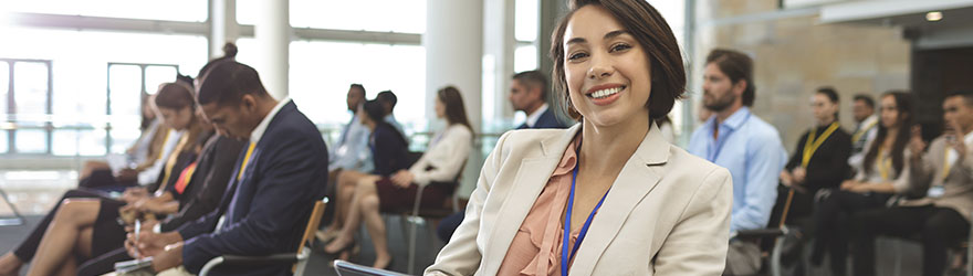 Conference event planner smiling at camera durning a conference session