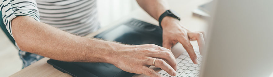 close up of hands with pen typing keyboard