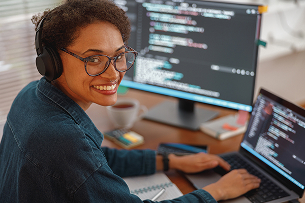 Software developer at desk smiling at camera