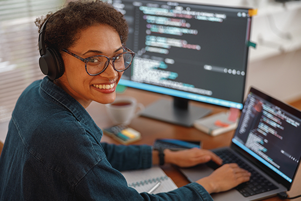 Software developer at desk smiling at camera