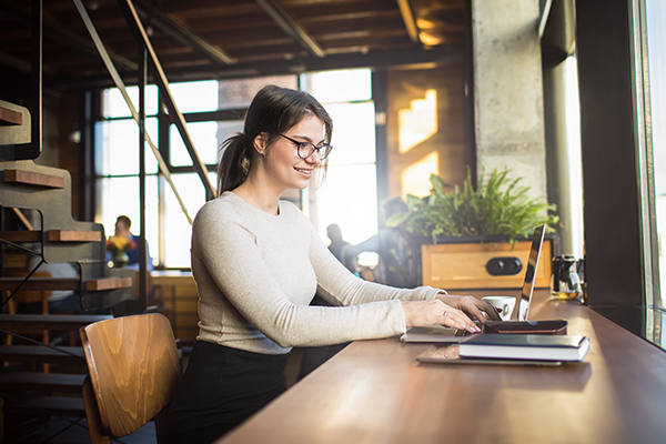 Writer in cafe working on laptop