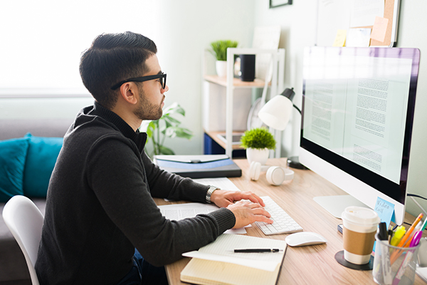 Writer in home office on desktop computer
