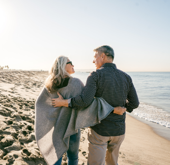 Couple in their 60s walking on the beach