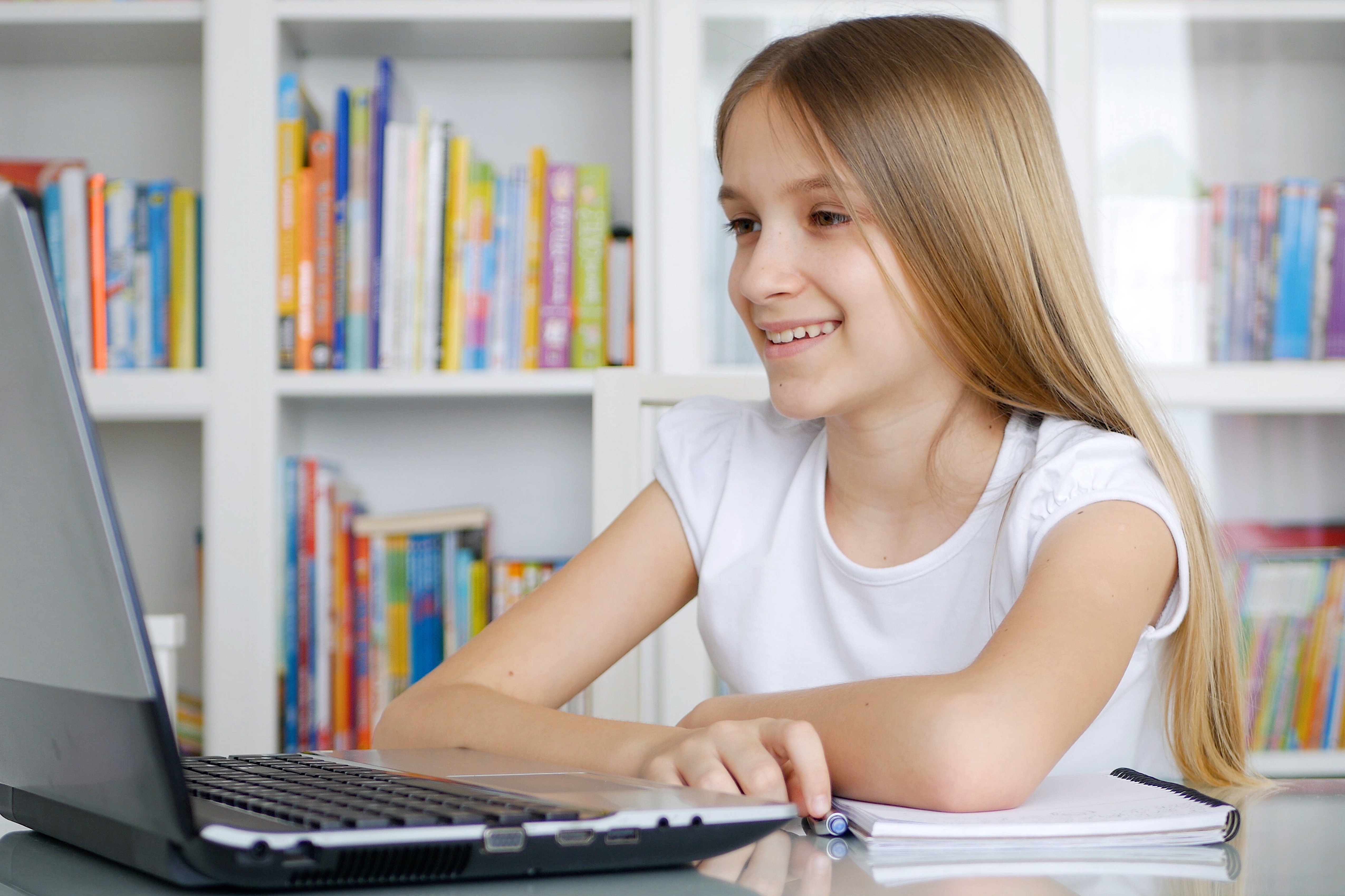 Young girl on laptop in a children's library