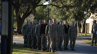 UWF Air Force ROTC students in uniform standing still at attention during a march around the UWF Pensacola campus.