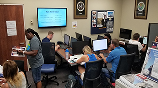 A small group of military students using computers in a computer lab.