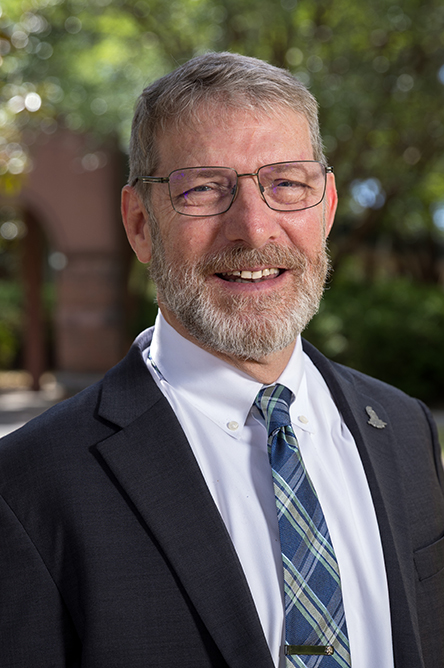 David Fugett outdoor headshot in suit and tie attire.