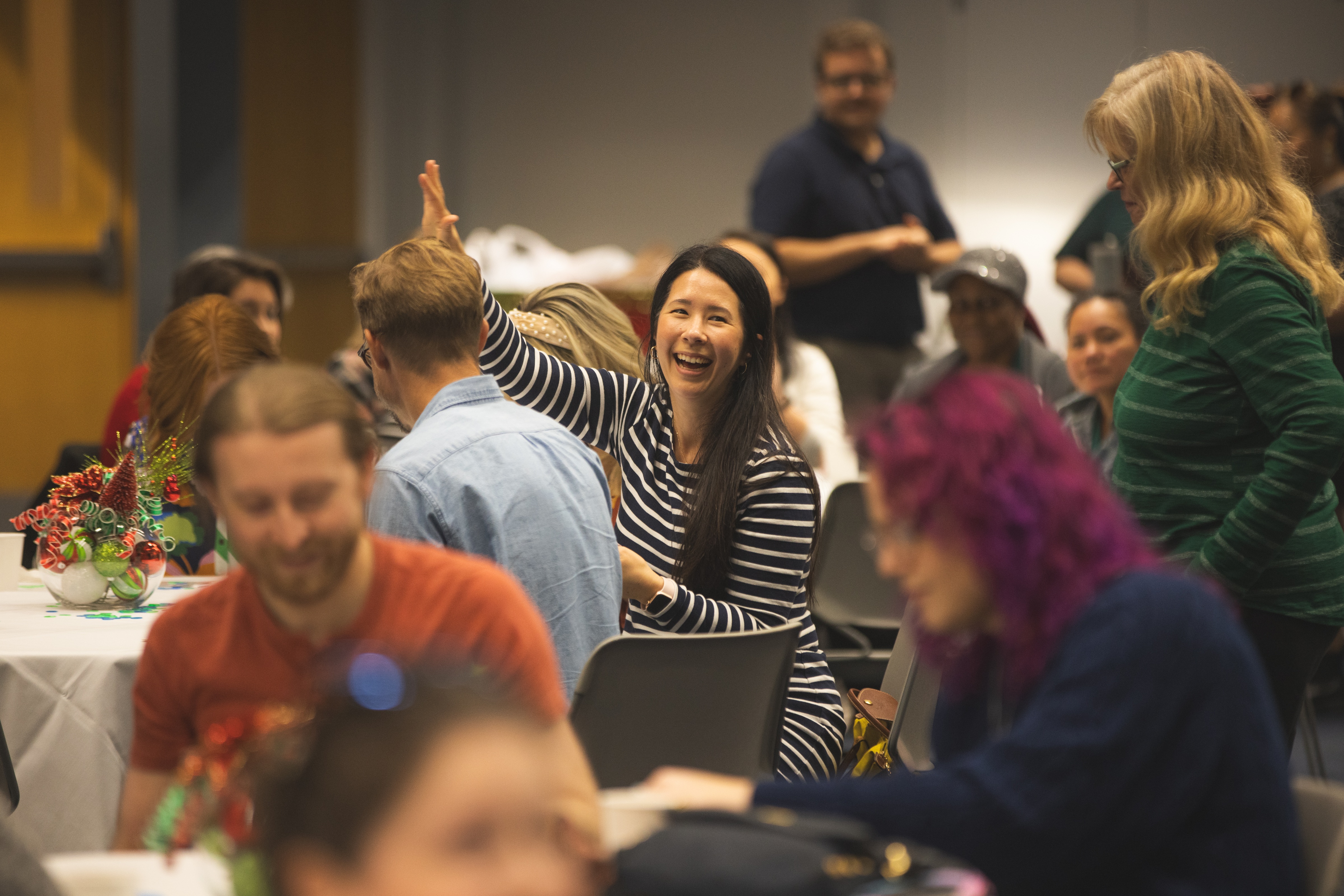 A women raising her hand in excitment from winning a game.