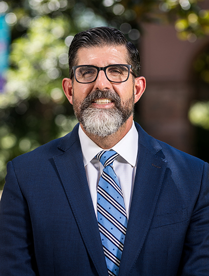 Outdoor portrait of Manny Diaz Jr. in a suit.