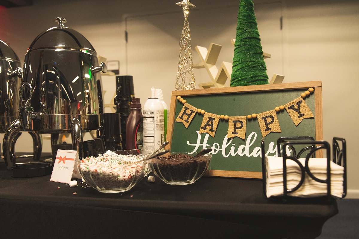 A photo of cocoa toppings and a sign that says Happy Holidays.