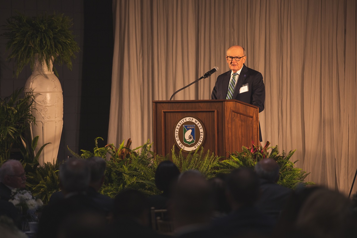 A photo of a man at a podium speaking.