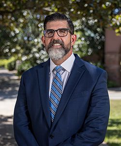 Outdoor portrait of Manny Diaz Jr. in professional attire.