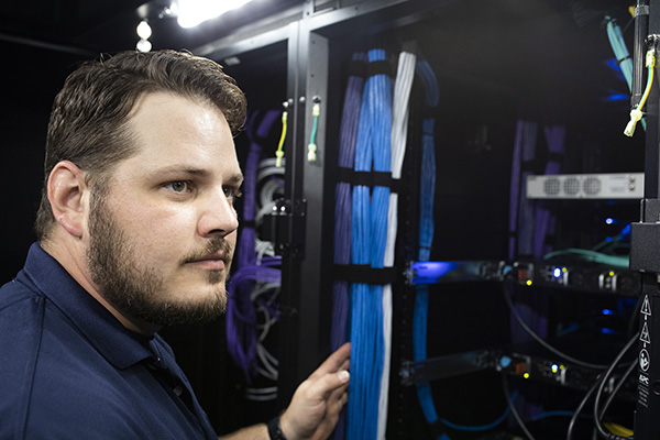 worker examining a server stack