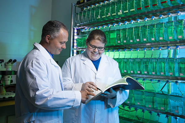 biology student and faculty reviewing lab data