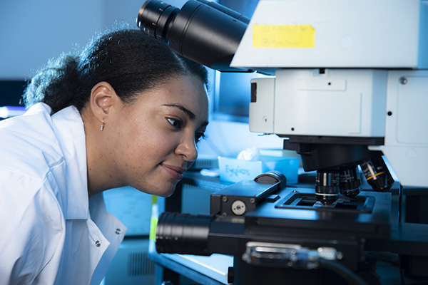 biology student configuring a microscrope