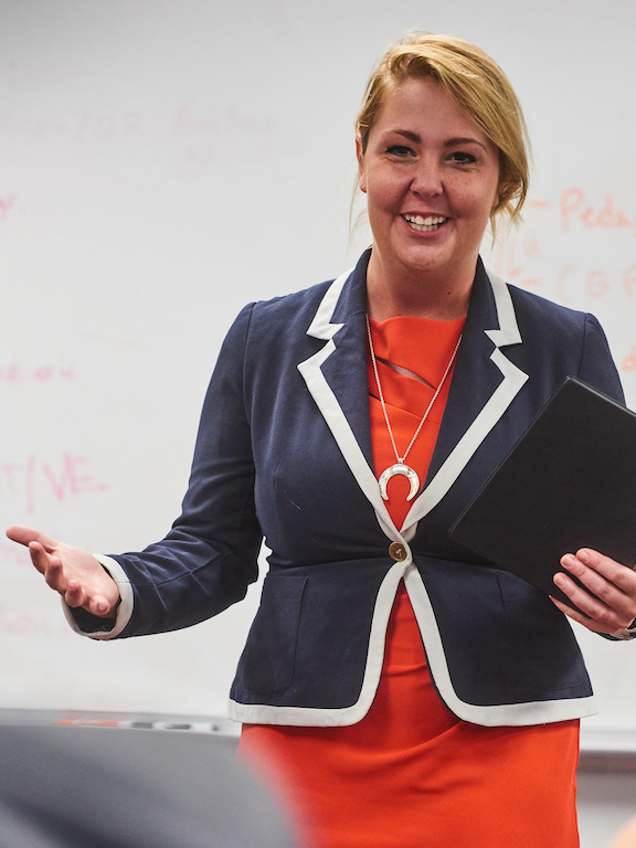 a woman giving a presentation to a class