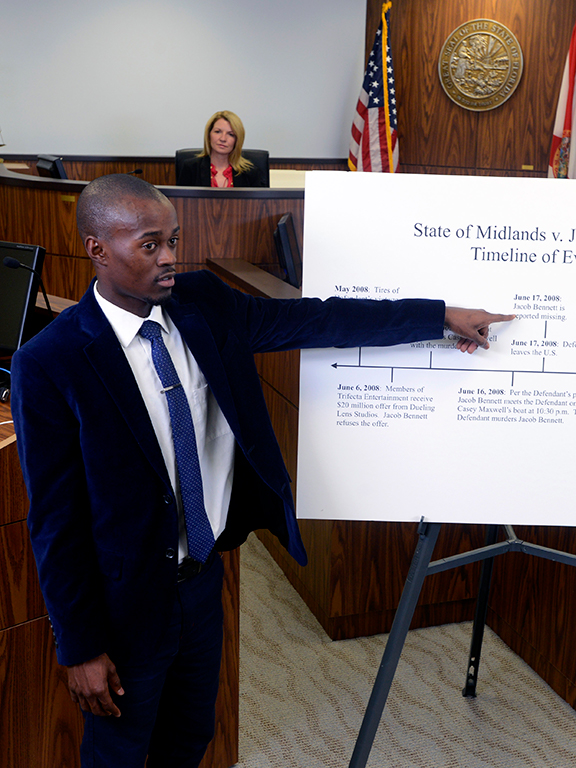 student presenting a poster in a mock trial