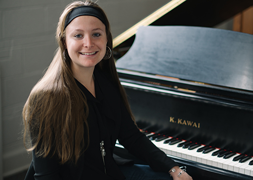 Dr. Patricia Izbicki sitting at a grand piano